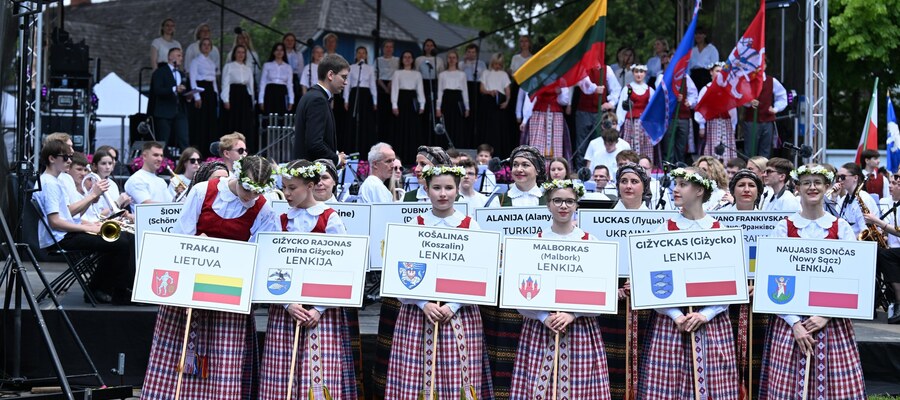 Przedstawicielki Trok w strojach ludowych z tabliczkami miast partnerskich