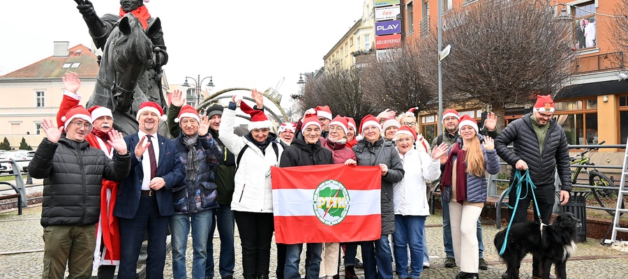 Przewodnicy PTTK z burmistrzem na tle pomnika